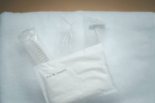 istock Razor, comb and toothbrush in package on white towel. Travel set 1290693742