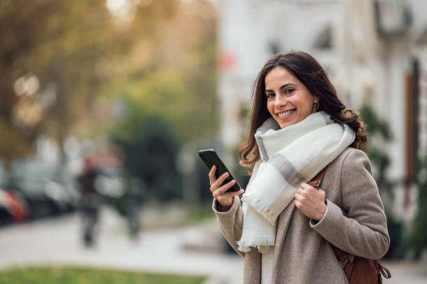 istock Using smart phone, standing in the city center. 1290697067