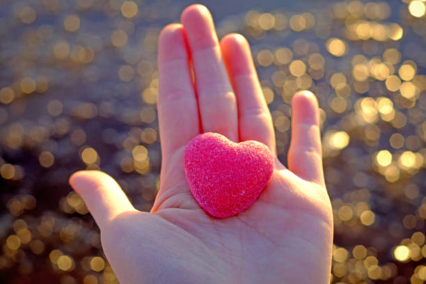 istock Red heart on the hand with natural bokeh background, selective focus, hope and support concept 1290698088