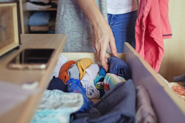 istock A woman is sorting through things in her home wardrobe with her hands. Folding clothes after washing. Household responsibilities, keeping the apartment clean and tidy 1290698646
