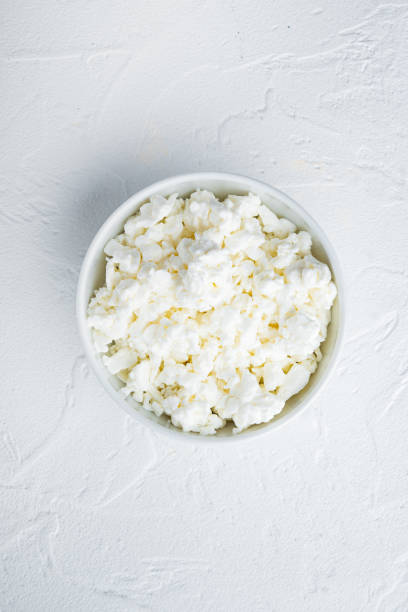 istock Cottage cheese or curd, on white textured background, flat lay 1290699225