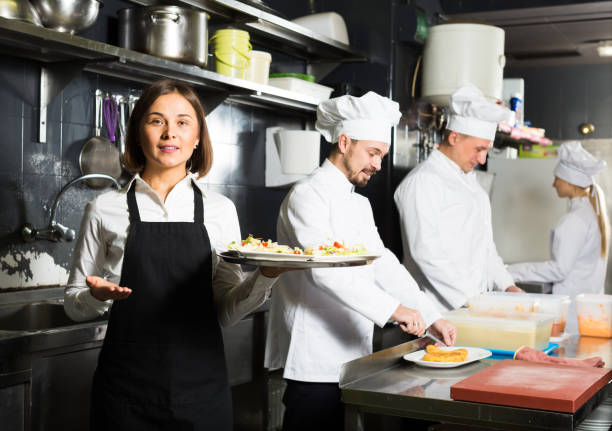 istock Happy female waiter taking ordered dishes 1290701931