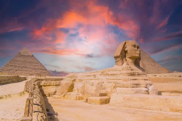 Photo of The Great Sphinx of Giza and in the background the Pyramids of Giza at sunset, the oldest funerary monument in the world. In the city of Cairo, Egypt