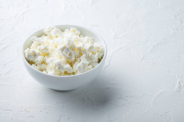 istock Cottage cheese or curd, on white textured background with space for text 1290702175