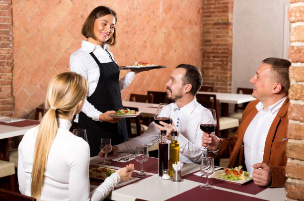 istock Waitress placing order in front of guests 1290702342