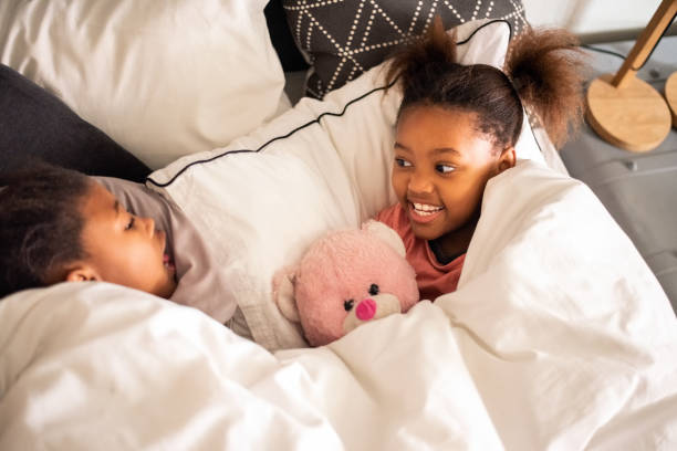 istock Sisters in playful mood on bed 1290703069