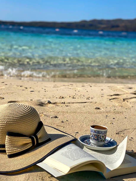 istock Holiday at the seaside with book, hat and coffee 1290703239