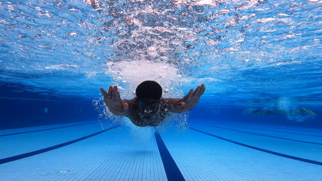 under water asian indian sportperson swimming butterfly style