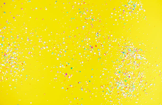 istock Colorful confetti on yellow table 1290707255