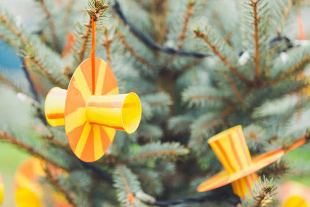 Handmade eco friendly decoration made of plastic cups and old CD or DVD discs on a Christmas tree. Diy ideas. Recycle, reuse, upcycling and zero waste concept. Selective focus, copy space