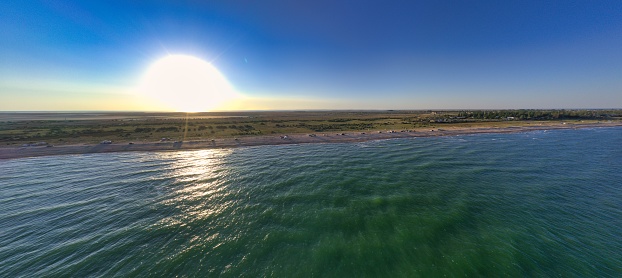 The edge of the sea in the evening sun. Camping beach. Drone shot 4K.