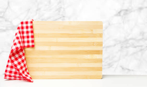 istock Wooden kitchen board with red checkered napkin on table 1290715664