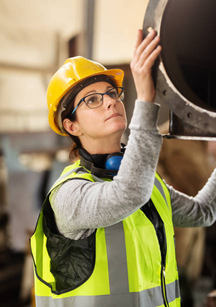 istock Female engineer inspecting a machine part in a warehouse 1290718594