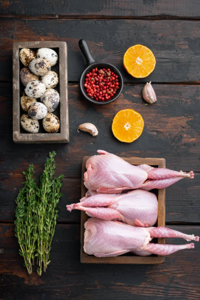 istock Fresh raw meat quails with herbs, flat lay, on dark wooden background 1290719299