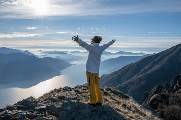 istock Hiker stands arms out on mountain top 1290719677