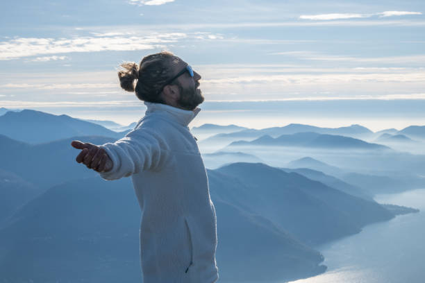 istock Hiker stands arms out on mountain top 1290719684