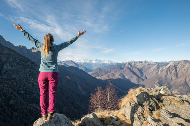 istock Hiker stands arms out on mountain top 1290719842