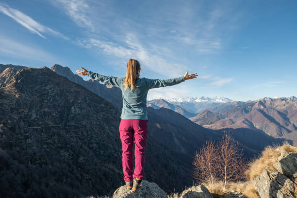 istock Hiker stands arms out on mountain top 1290720557