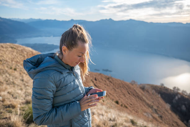 istock Woman hiker uses phone on mountain 1290720892