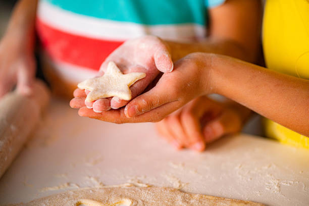 Close up of children hands holding homemade cookie ready for bake