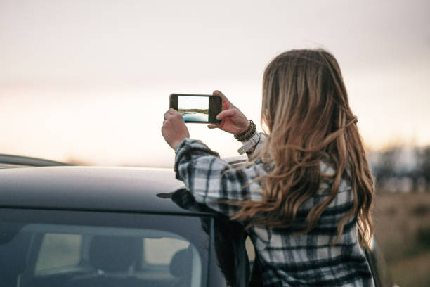istock Young woman taking a picture from a car 1290723416