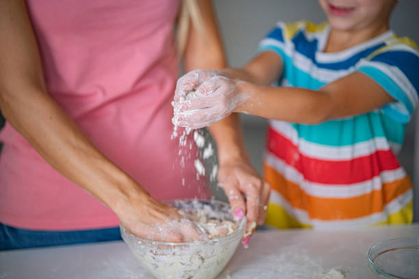 istock Little boy helping his mother to making cookies 1290723988