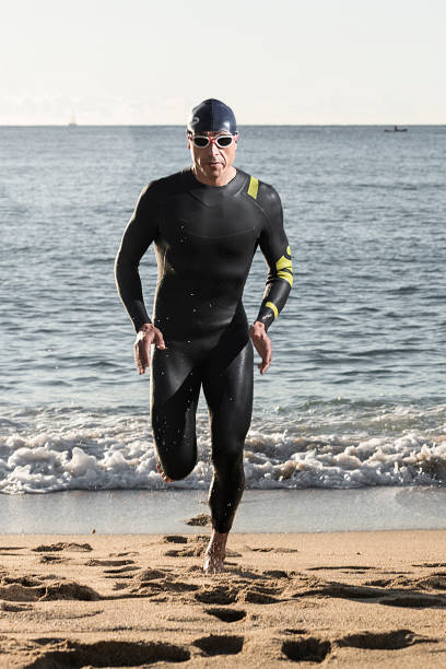istock Triathlete running out of the water. 1290724739