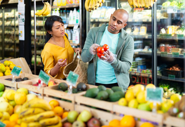 istock Married couple choosing tomatoes at grocery store 1290728904