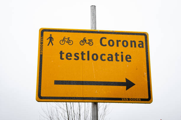 Direction sign to a corona test location Gouda, Netherlands - December 2020: Direction sign indicating the way to a corona test street for walkers, cyclists and mopeds. Translation: testlocatie means test location. gouda south holland stock pictures, royalty-free photos & images