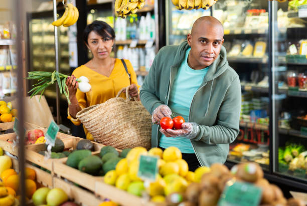 istock Married couple choosing tomatoes at grocery store 1290735123