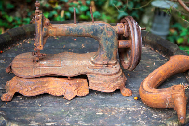 Rusty vintage sewing machine on a wooden table in the garden