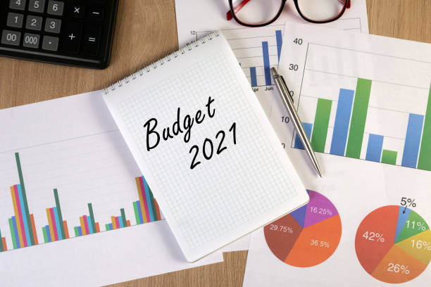 istock Blank notepad with financial graphs, eyeglasses, pen and calculator on the workplace. 1290736319