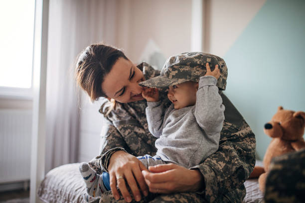 giovane soldato donna incontra il suo figlio dopo molto tempo - soldier hat foto e immagini stock