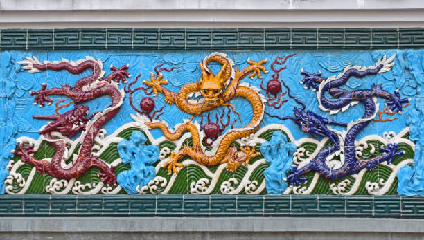 istock Fragment of the wall with three dragons 1290738416
