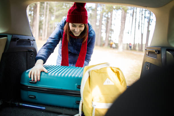 istock Happy young woman packing for a winter vacation 1290738497