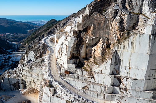 Carrara, Tuscany, Italy - June 1, 2017: view of the Carrara marble quarries with the Ligurian Sea in the background