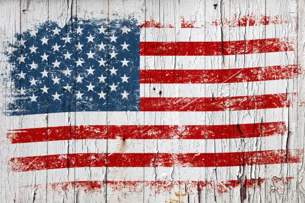Grunge American flag on old weathered white painted wooden surface background