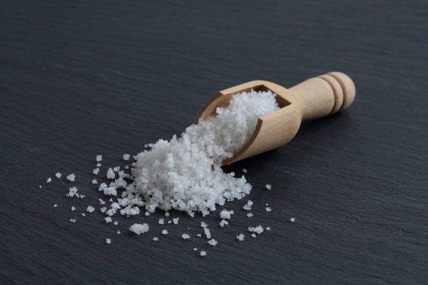 Flower of salt of Guerande - France. Crystals of natural higth quality sea salt from Guerande - France harvested by hand and named "Fleur de sel" in a wooden spoon on the slate surface. loire atlantique photos stock pictures, royalty-free photos & images