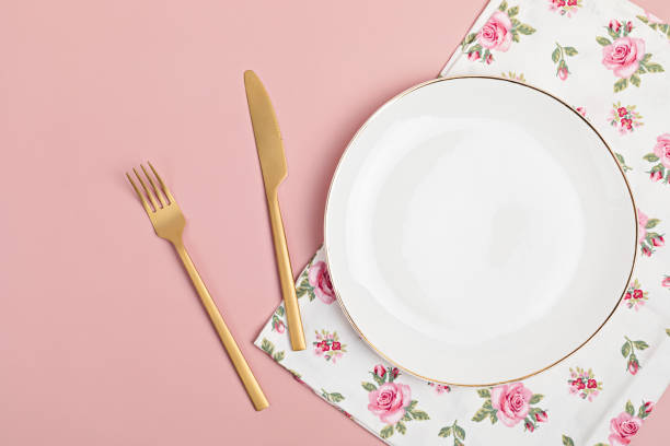 istock Empty white plate and cotton napkin on pink backdrop. Food background for menu, recipe book. Table setting. Flatlay, top view 1290744932