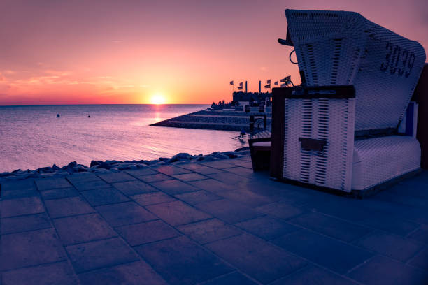 Sunset at North Sea in Germany with beach basket chair
