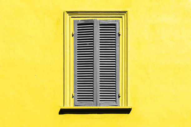 istock Ultimate grey and illuminating yellow. Gray shutters on the window 1290747247