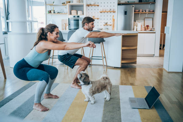 casal se exercitando juntos em casa. - crouching - fotografias e filmes do acervo