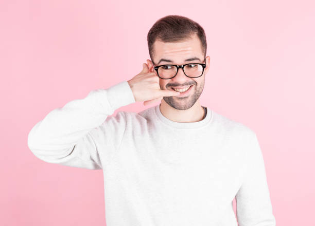istock Young handsome man with beard smiling doing phone gesture with hand and fingers like talking on the telephone. 1290754636