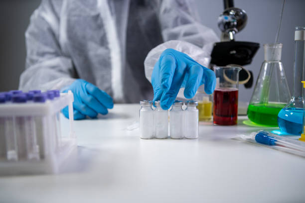 istock Development and search for drug for coronavirus. Chemist examining ampoule of powdered antibiotic for injection. Treating bacterial infection with medications. Covid 19 health and treatment concept 1290757619
