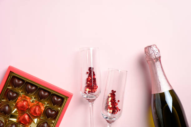 istock Romantic flat lay composition with champagne bottle, glasses, sweets on pink background. Happy Valentines Day celebration concept. Flat lay, top view. 1290760854