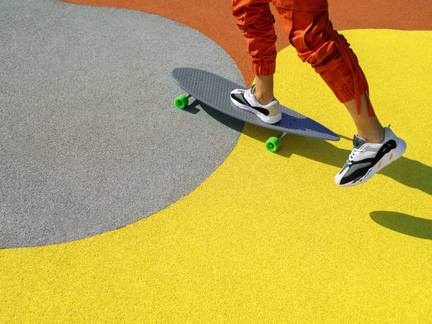 in sella a uno skateboard sullo sfondo illuminante - skateboard park foto e immagini stock