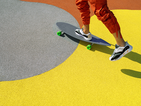 Unrecognisable man riding a longboard on the cityscape background. Extreme sport, leisure activity, motion concept. Main color trend. Color of the year 2021 illuminating and ultimate gray background.