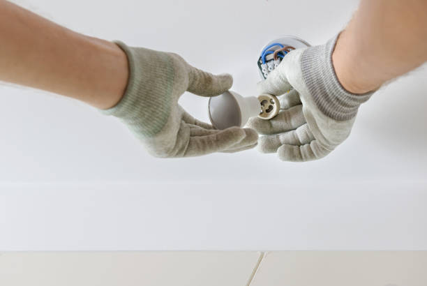 istock A worker is installing an LED spotlight on the ceiling. 1290763950