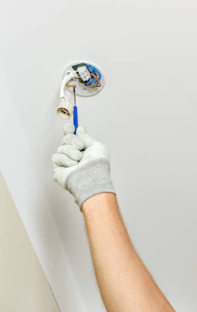istock A worker is installing an LED spotlight on the ceiling. 1290763953