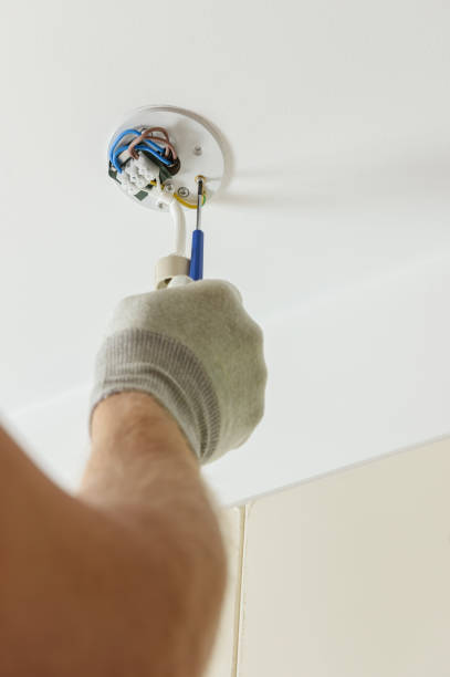 istock A worker is installing an LED spotlight on the ceiling. 1290763956